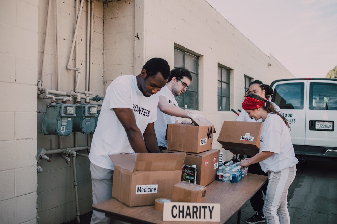 Volunteers sort and prepare donations outdoors for a charitable event.